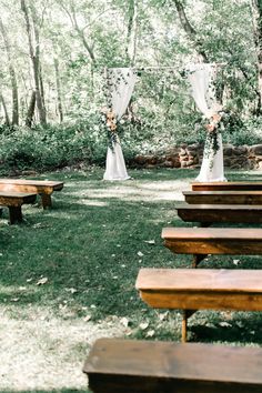 an outdoor ceremony setup with wooden benches