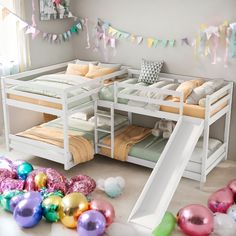 bunk beds with slides and balloons on the floor