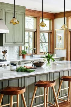 a kitchen with wooden stools and green cabinets