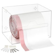 a roll of pink and white paper next to other items in a clear box on a white background