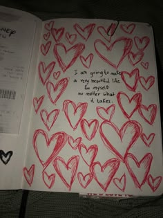 an open notebook with hearts drawn on it