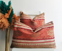 two decorative pillows sitting on top of a white shelf