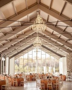 an indoor wedding venue with chandeliers and tables