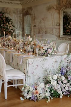 a table with flowers and candles is set up for a formal dinner or wedding reception