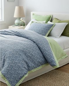 a bed with blue and green comforters in a bedroom