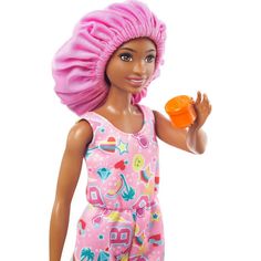 the doll is wearing a pink hat and holding an orange object in her hand,