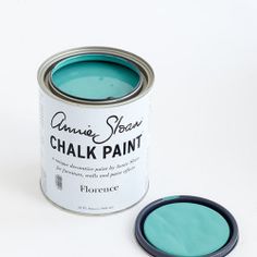 a can of chalk paint sitting next to a small black object on a white surface