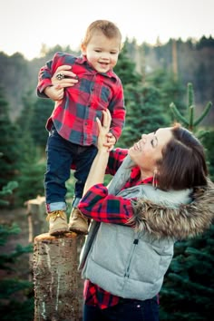 a woman holding a small child on top of a tree