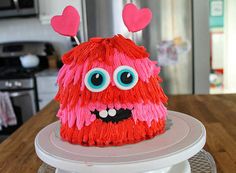 a cake that has been decorated to look like a monster with hearts on its ears