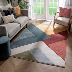 a living room filled with furniture and a large rug on top of a hard wood floor