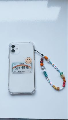 a cell phone case with a lanyard attached to it and a smiling face on the back