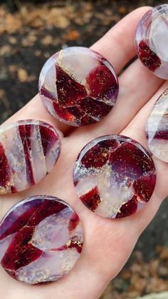 four red and white marbles sitting on someone's hand