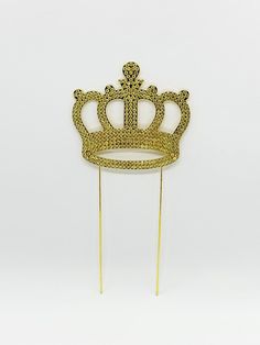 a gold crown on top of a toothpick in the shape of a stick