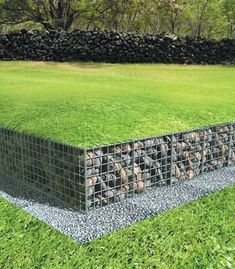 a large grassy field with rocks in the middle and grass growing on it's sides