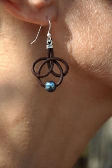 a close up of a person's ear wearing earrings with blue beads on them