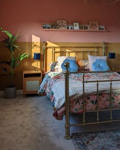 a bed room with a neatly made bed and a potted plant