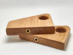 two pieces of wood sitting on top of each other with holes in the middle and eyes