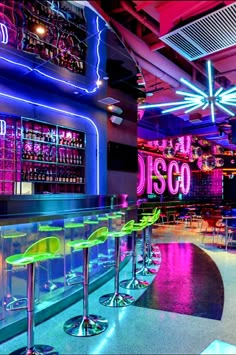 the inside of a restaurant with neon lights and bar stools in front of it