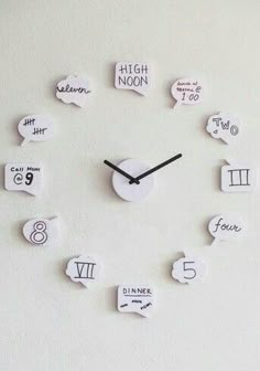 a clock made out of white paper with numbers and speech bubbles on the face that read high noon