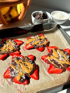 chocolate covered strawberries with peanut butter drizzled on them, sitting on a baking sheet