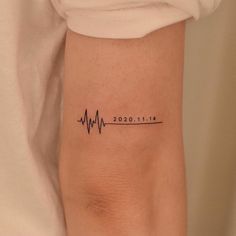 a woman's arm with a heartbeat tattoo on it