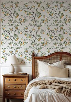 a bed sitting under a wallpaper covered in oranges