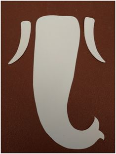 the letter j is made up of white paper on a brown leather textured surface