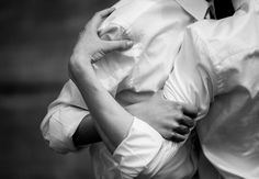 black and white photograph of a woman holding her husband's back with both hands