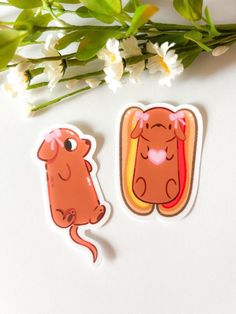 two stickers with animals on them next to flowers