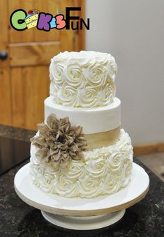 a three tiered cake with white frosting and flowers