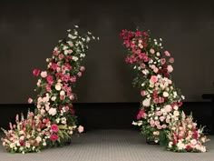 two floral arrangements are arranged in the shape of an arch with pink and white flowers