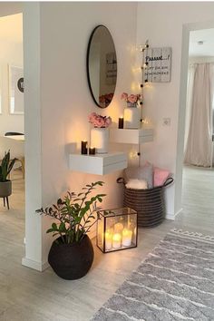 a living room with candles on the wall and plants in vases next to it