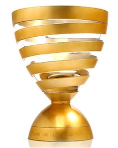 a gold colored vase sitting on top of a white table