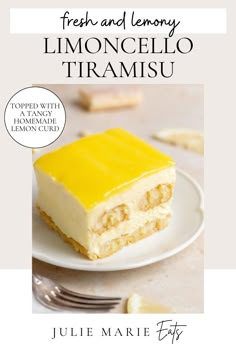 a white plate topped with a piece of cake covered in yellow frosting and sitting on top of a table