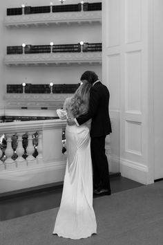 a bride and groom kiss in front of the piano