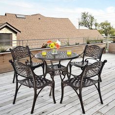 an outdoor table and chairs on a wooden deck