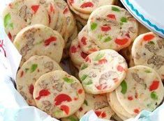 a bunch of cookies that are sitting in a bowl on a table with some napkins