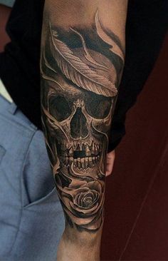 a man's arm with a skull and rose tattoo design on the left forearm