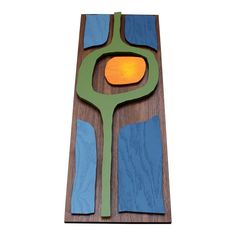 a piece of wood with blue and green shapes on it