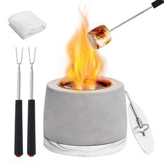 an outdoor fire pit with tongs, spatula and pizza on the top burner