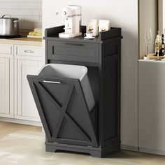 a black trash can sitting next to a kitchen counter