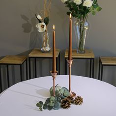 two candles are sitting on top of a white table