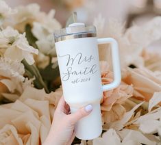 a person holding a white coffee mug with the words mrs and mr etched on it