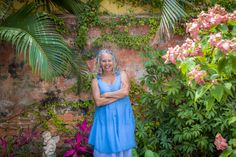 a woman is standing in front of some flowers