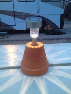 an orange cone light sitting on top of a table next to a white and black bus