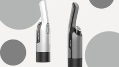 two electric toothbrushes sitting next to each other on a gray and white background