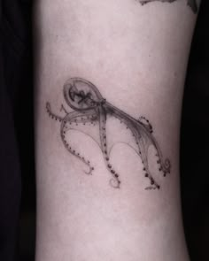 an octopus tattoo on the right thigh with dots in it's tentacles and tail