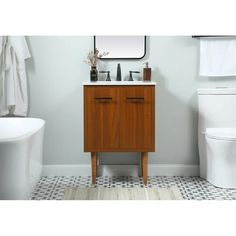 a white toilet sitting next to a wooden cabinet in a bathroom under a mirror and sink