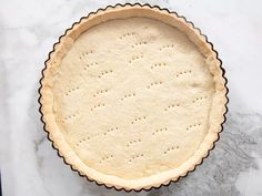 an uncooked pie crust on a marble counter top