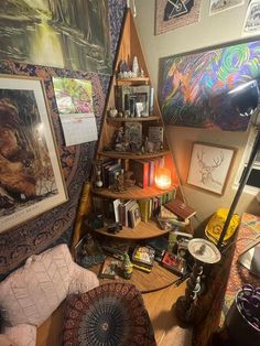 a room filled with lots of books and pictures on the wall next to a lamp